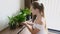 Young Smiling Woman Pouring from Watering Can Growing Flowers