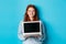 Young smiling woman with red hair and freckles showing computer screen, holding laptop and demonstrate online promo