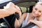 Young smiling woman sitting in car taking key