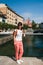 Young smiling woman tourist standing on a bridge in the old centre of Ljubljana, Slovenia, wearing white shirt, white