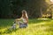 Young smiling woman training french bulldog in park.