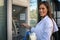 Young smiling woman using card at ATM . Looking at camera.