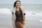 Young smiling woman walking by a sea beach, autumn fashion, heal