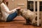 Young smiling woman in white shirt sit and caress dog by hand in kitchen