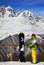 Young snowboarder with helmet in hands and snowboard on viewpoint in winter mountain at sun day