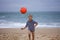 Young soccer player plays barefoot on the ocean shore. Football, sport, passion. Active lifestyle