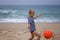 Young soccer player plays barefoot on the ocean shore. Football, sport, passion. Active lifestyle