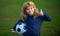 Young soccer player in sportswear with soccer ball show thumbs up success sign. Cheerful little boy enjoy soccer