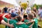 Young Soccer Players Holding Trophy. Boys Celebrating Soccer Football Championship