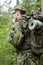 Young soldier with backpack in forest