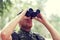 Young soldier or hunter with binocular in forest