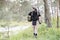 Young soldier in uniforms and tactical vest works in the forest and prepares for action at a temporary forest base. A man does in