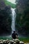 A young solo man admiring a waterfall