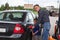 Young son looking at father refilling car