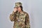 Young south asian woman wearing camouflage army uniform tired rubbing nose and eyes feeling fatigue and headache