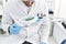 Young south east man wearing scientist uniform looking sample using magnifying glass at laboratory