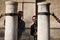 Young Spanish gay male couple have fun among the marble columns and chains in the city. They are on their honeymoon vacation. The