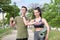 Young sport couple looking at fitness smartwatch and drinking water while standing at a park