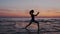 Young sport and flex woman exercising yoga, doing warrior pose on beach during sundown sky. silhouette of a slim and fit