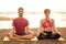 Young sportive couple girl and boy are practicing acroyoga exercises in the sunset on the beach