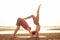 Young sportive couple girl and boy are practicing acroyoga exercises in the sunset on the beach