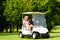 Young sportive couple with golf cart on a course