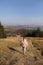 Young sportive woman is holding yoga mat and going in the mountains after exercises. back view. selective focus