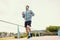 Young sportman hold water bottle between jogging and listening music in the park