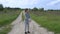 A young sports female does a warm-up in the fresh air in the middle of a dirt road outside the city. Slow-motion.