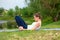 A young sports girl practices yoga on a green lawn by the river, yoga assans posture. Meditation and unity with nature