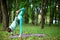 A young sports girl practices yoga in a quit green summer forest, yoga assans posture. Meditation and unity with nature