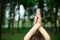 A young sports girl practices yoga in a quit green summer forest, yoga assans posture. Meditation and unity with nature