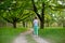 A young sports girl running in a quit green summer forest. Sport and wellness