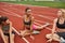 Young sports girls stretch on stadium treadmill