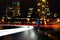 Young Sports Man Running on the Night Road with Cars Light Trails. Healthy Lifestyle and Urban Sport Concept.