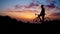 Young sports man sitting on a bike on a mountain top in a yellow t-shirt helmet and sports equipment looking at the