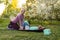 Young sports mother doing physics exercise outdoors in garden near her daughter. Healthy lifestyle. Yoga. Fitness