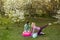 Young sports mother doing physics exercise outdoors in garden near her daughter. Healthy lifestyle. Yoga. Fitness