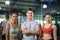 Young sports people and trainer in fitness gym, man with crossed hands and two women fit sporty, Sport and fitness concepts