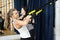 Young sports woman in gym using equipment trx