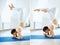 Young sports woman in white sportswear doing headstand yoga pose in a gym with white wall background. Collage
