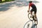 Young sportsman in helmet riding racing bicycle while working out