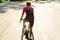 Young sportsman in helmet riding racing bicycle while working out