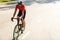 Young sportsman in helmet riding racing bicycle while working out