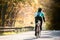 Young sportsman riding bicycle outside in sunny autumn nature