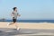 Young sportsman running on the seafront of the beach