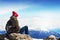 Young sportsman or traveler sitting on stone and looking on horizon. Mountain range on background. Beautiful Landscape.