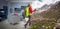 young sportswoman with backpack and hiking equipment dreaming about hiking