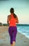 Young sportswoman on beach in evening jogging