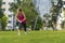 Young sportswoman performing exercises on the grass in a city